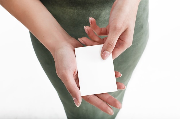 Woman holds white card in her hand