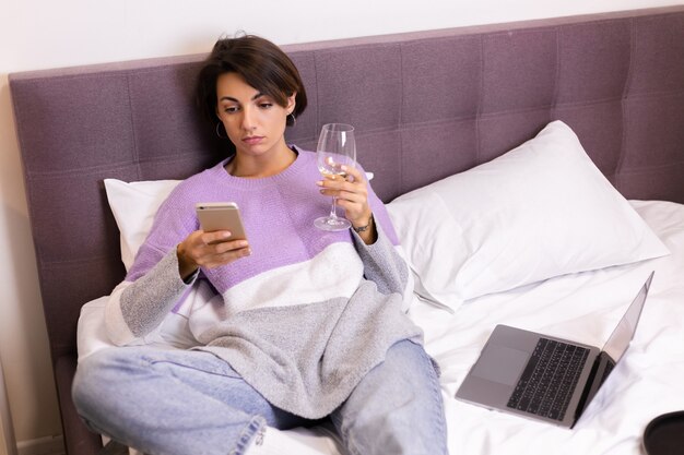 Foto gratuita la donna a casa annoiata stanca si è addormentata con un bicchiere di vino e il telefono in mano