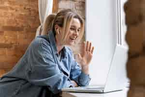 Free photo woman at home having videocall with family