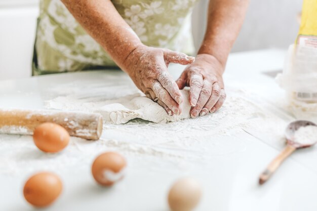 Woman at home kneading dough for cooking pasta pizza or bread. Home cooking concept. Lifestyle