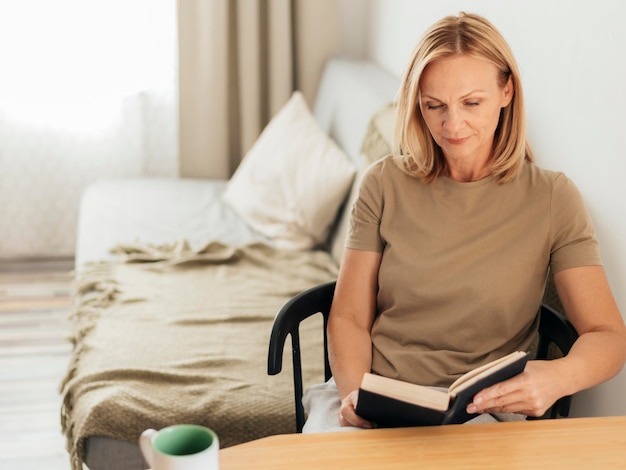 Woman at home reading book during quarantine