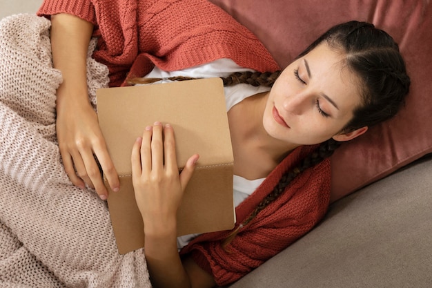 自宅で読書をしている女性