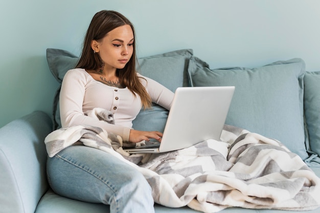 Foto gratuita donna a casa che lavora al computer portatile durante la pandemia