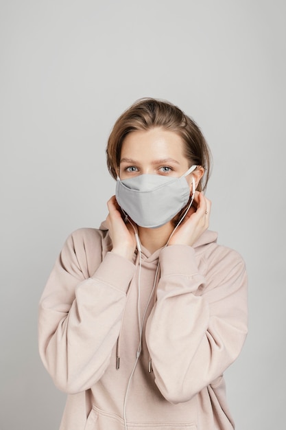 Foto gratuita donna in felpa con cappuccio con maschera