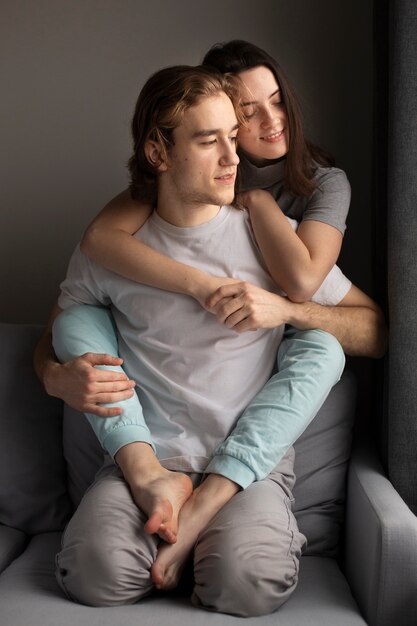 Woman hugging boyfriends on sofa