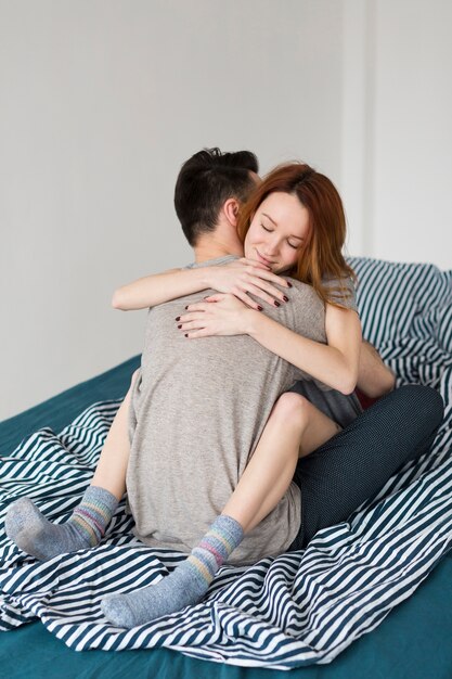 Woman hugging her boyfriend indoors