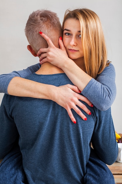 Foto gratuita donna che abbraccia il suo ragazzo in cucina