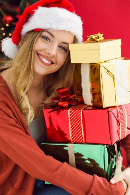 Woman hugging a mountain of colorful gifts in her hands