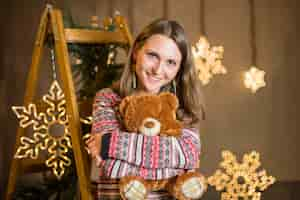 Free photo woman hugging teddy at christmas