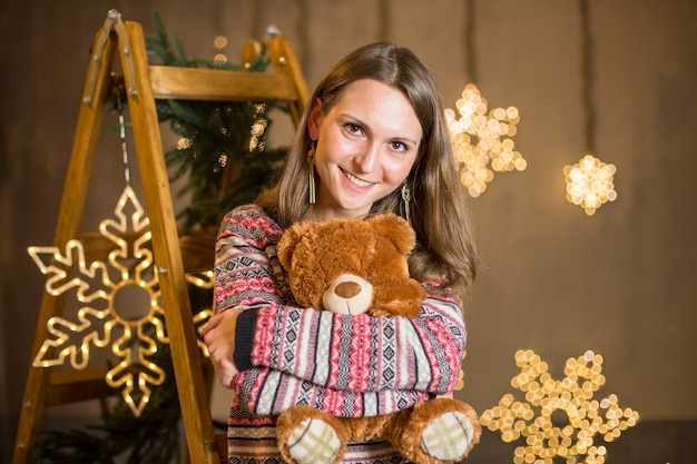 Woman hugging teddy at christmas