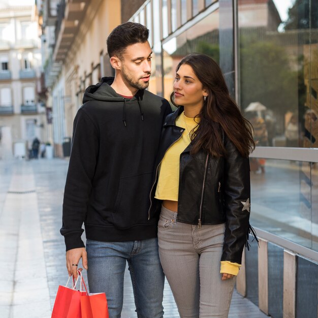 買い物をしている若い男を抱擁する女性