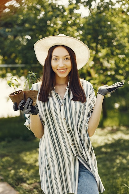 화분을 들고 모자에있는 여자