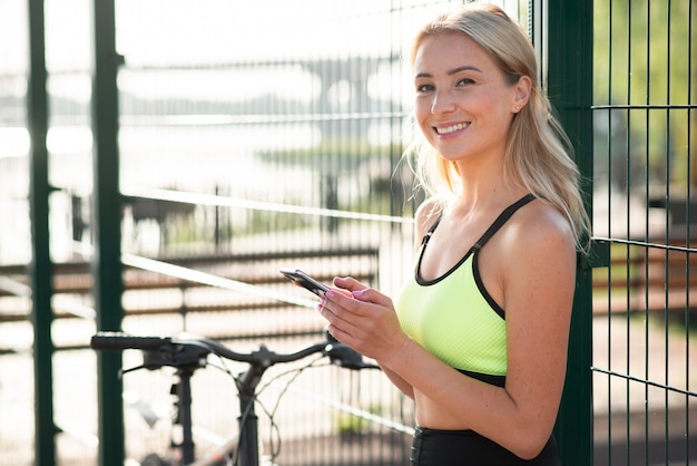 無料写真 彼女の携帯電話を使用してフィットネスの服の女性