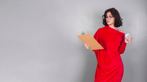 Бесплатное фото Женщина в красном с буфером обмена и кредитной картой