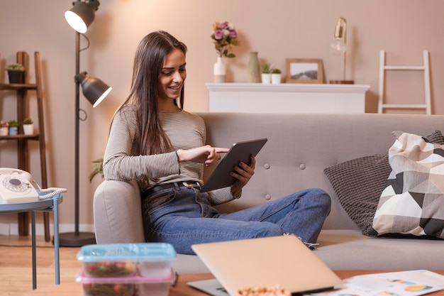 Foto gratuita donna che lavora al chiuso su tavoletta digitale