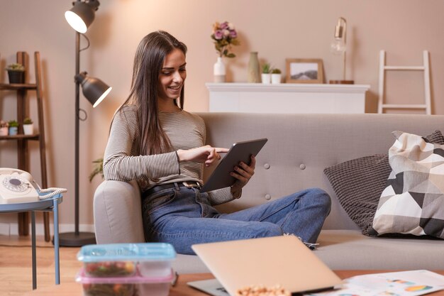 Woman indoors working on digital tablet