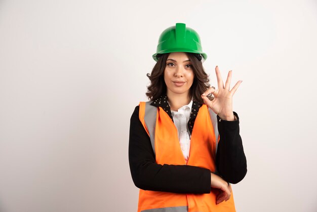 Промышленный рабочий женщина показывает знак ОК на белом