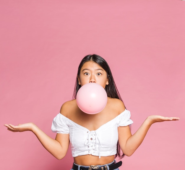 Woman inflates a pink balloon