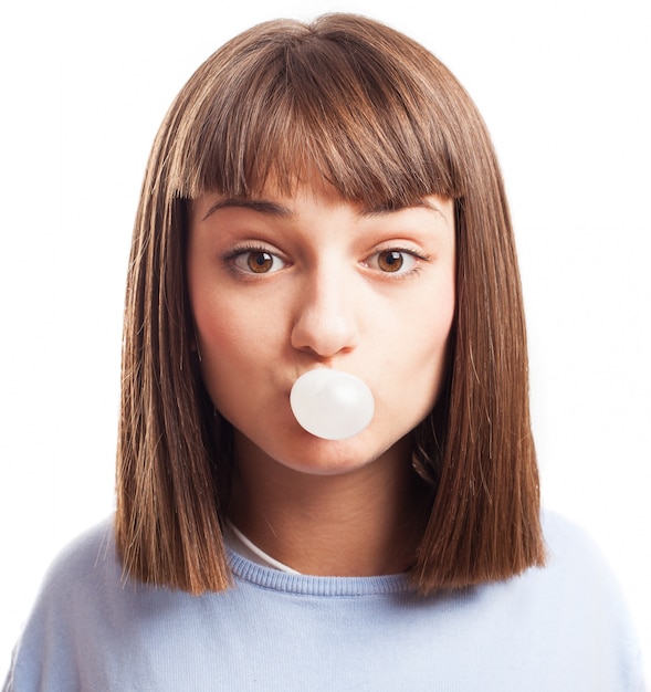 Woman inflating a chewing gum