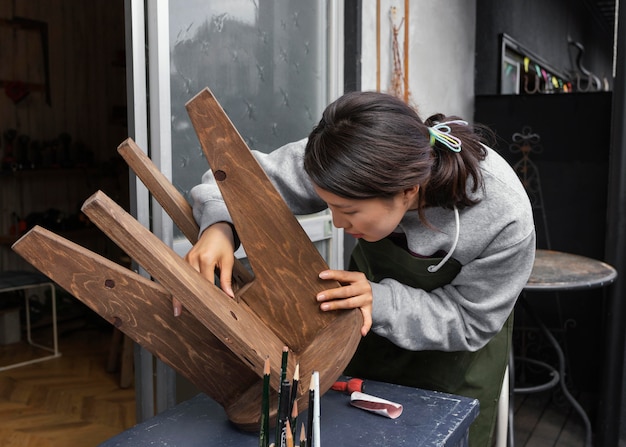 Free photo woman inspecting chair medium shot