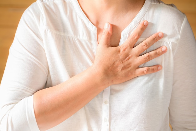 Woman is clutching her chest