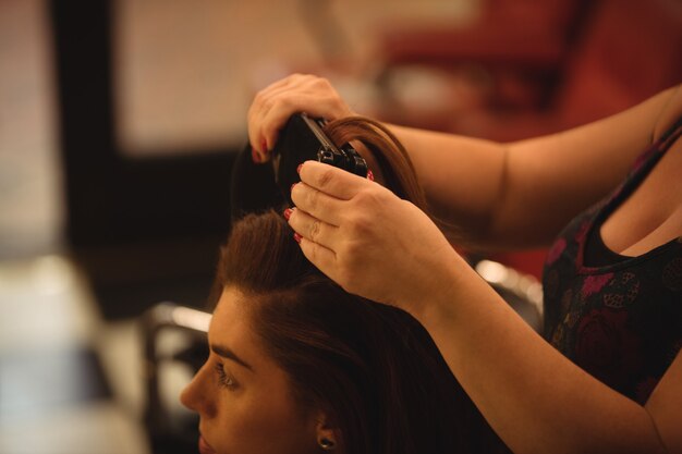 Woman is getting her hair straightened