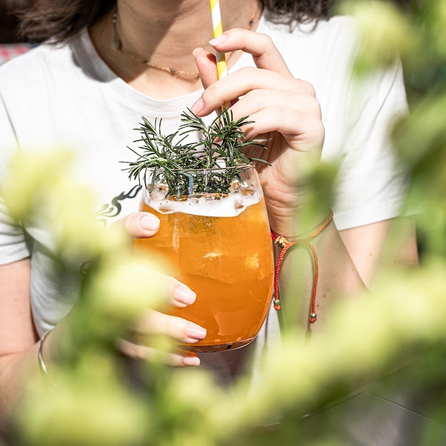 Woman is holding a glass of iced cocktail