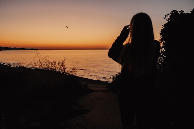 無料写真 女性は夕方の湖を見ています。