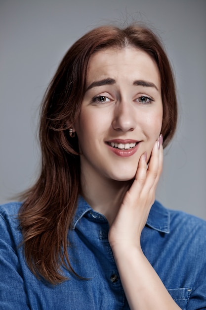 Woman is looking imploring over gray background