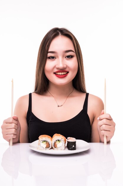 女性は白で隔離される木の箸を使用して味の巻き寿司を食べる準備ができて