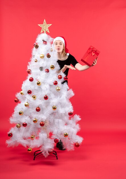 Una donna è in piedi accanto all'albero di natale