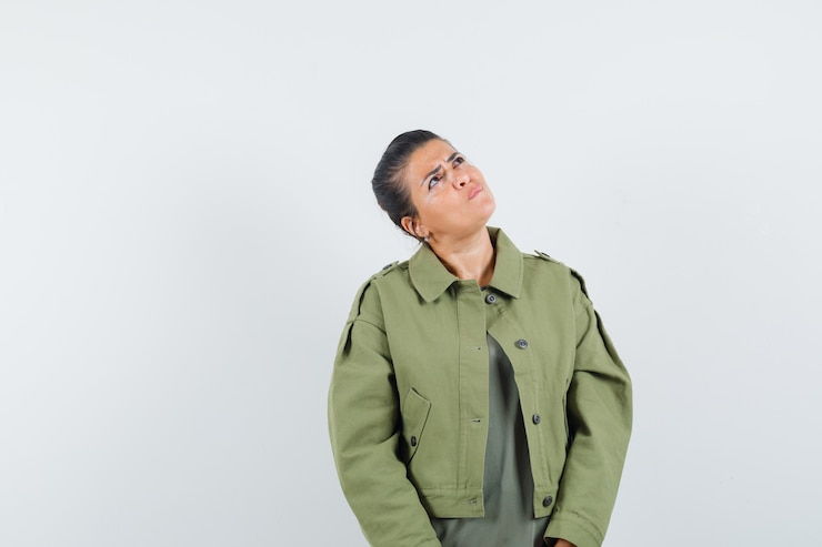 Free Photo woman in jacket, t-shirt looking up and looking hesitant