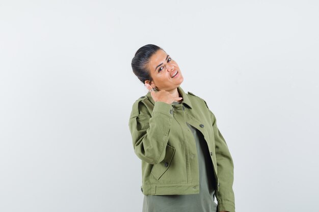 woman in jacket, t-shirt showing phone gesture and looking confident