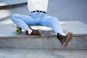 Free photo woman in jeans sitting on longboard