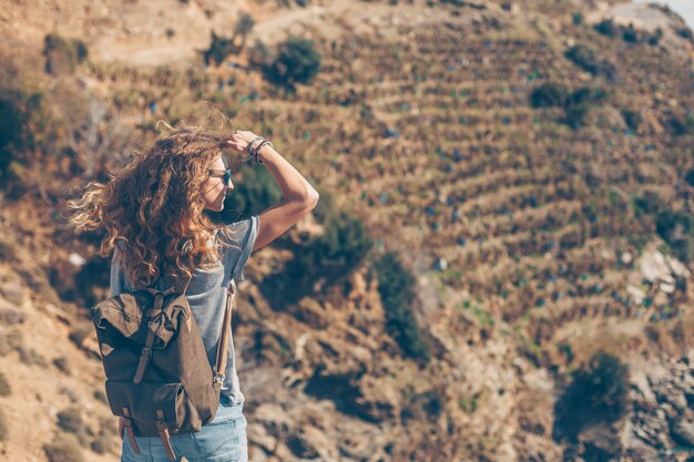 woman in jeans and t-shirt standing in nature during daytime