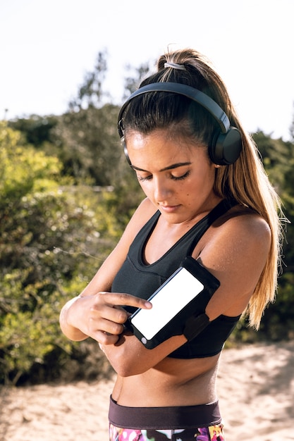 Woman at jogging putting music on her phone mock-up