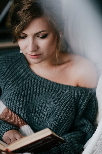 Woman in jumper reading book