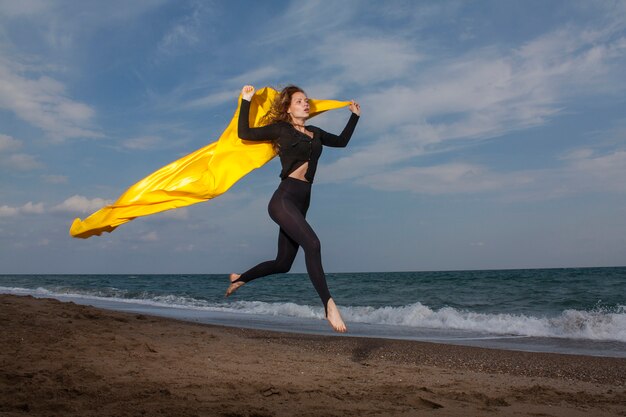 Женщина прыгает на пляже