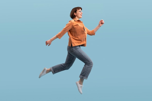 Woman jumping isolated on blue