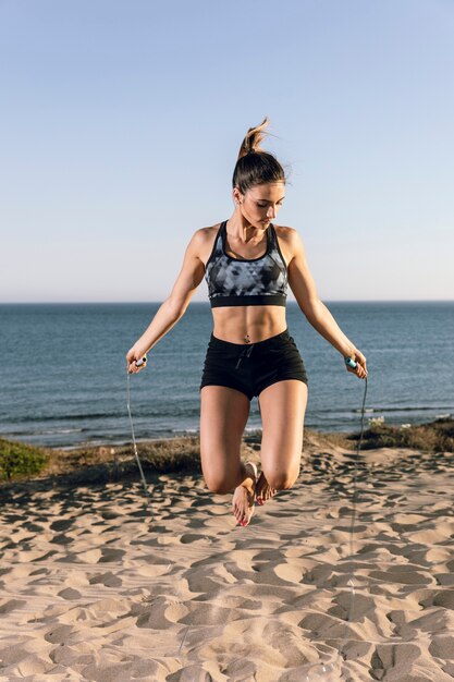 Woman jumping rope at the beach