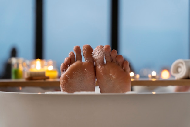 Woman keeping her feet above the water while taking a bath