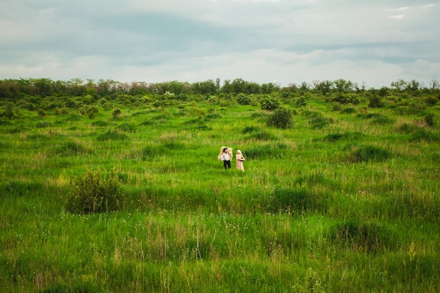 ハンカチの女性と牧草地を歩いている男性