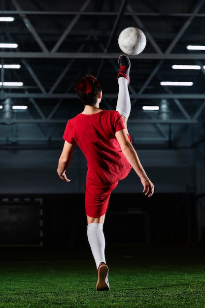 Woman kicking football ball