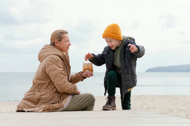 Woman and kid at beach full shot