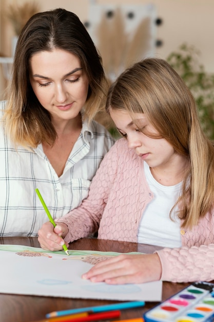 Woman and kid drawing together close-up