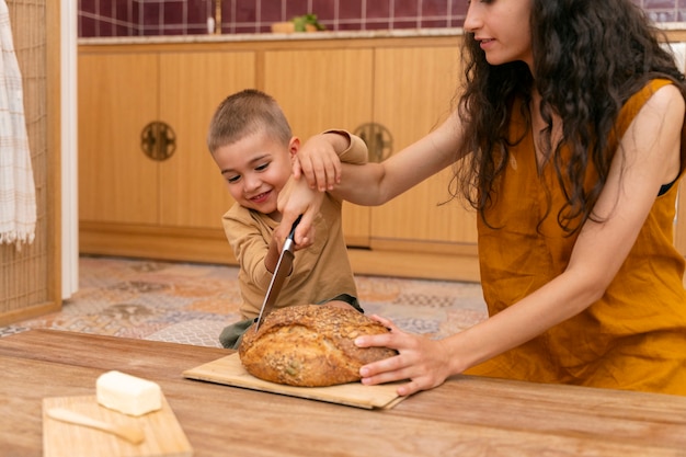 Woman and kid in kitchen side view