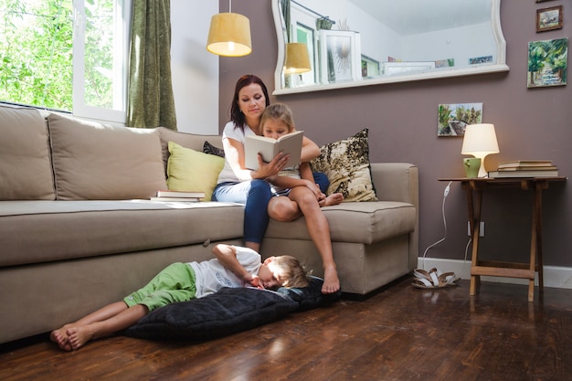 Woman and kids relaxing reading book