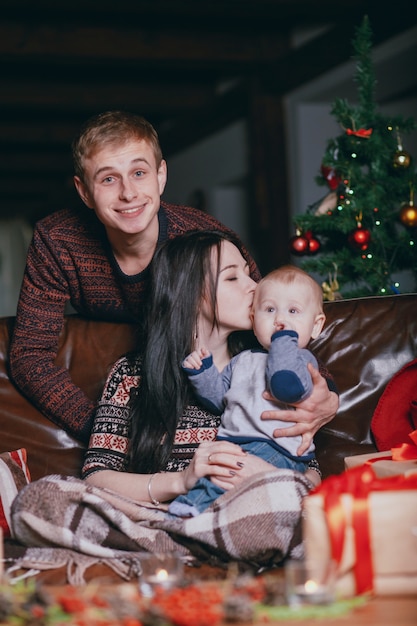 Donna che bacia il suo bambino sulla testa, mentre i sorrisi padre