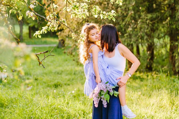 Woman kissing her daughter in park