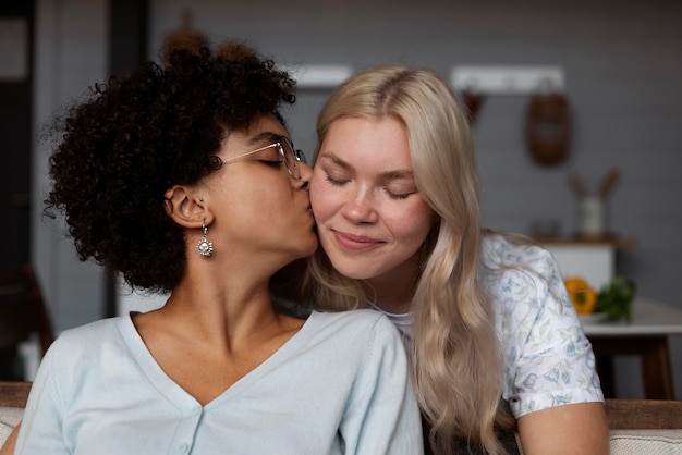 頬に彼女のガールフレンドにキスする女性